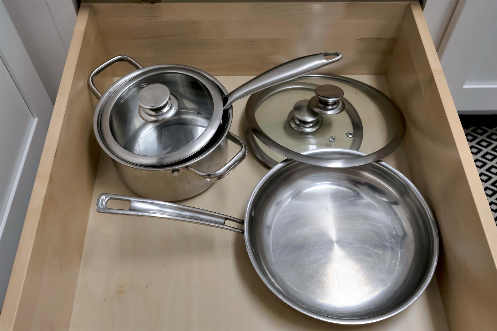 Your kitchen drawer comes stocked with quality stainless cookware—two covered pots and a frying pan ready for preparing your favorite home-cooked meals.
