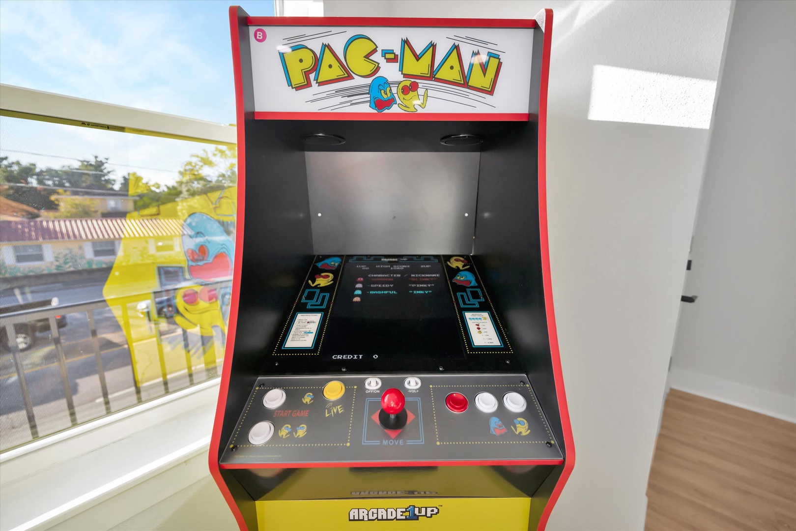 Challenge your travel companions to a classic arcade showdown on this vintage Pac-Man machine, perfectly positioned to overlook the vibrant neighborhood views during your downtime.