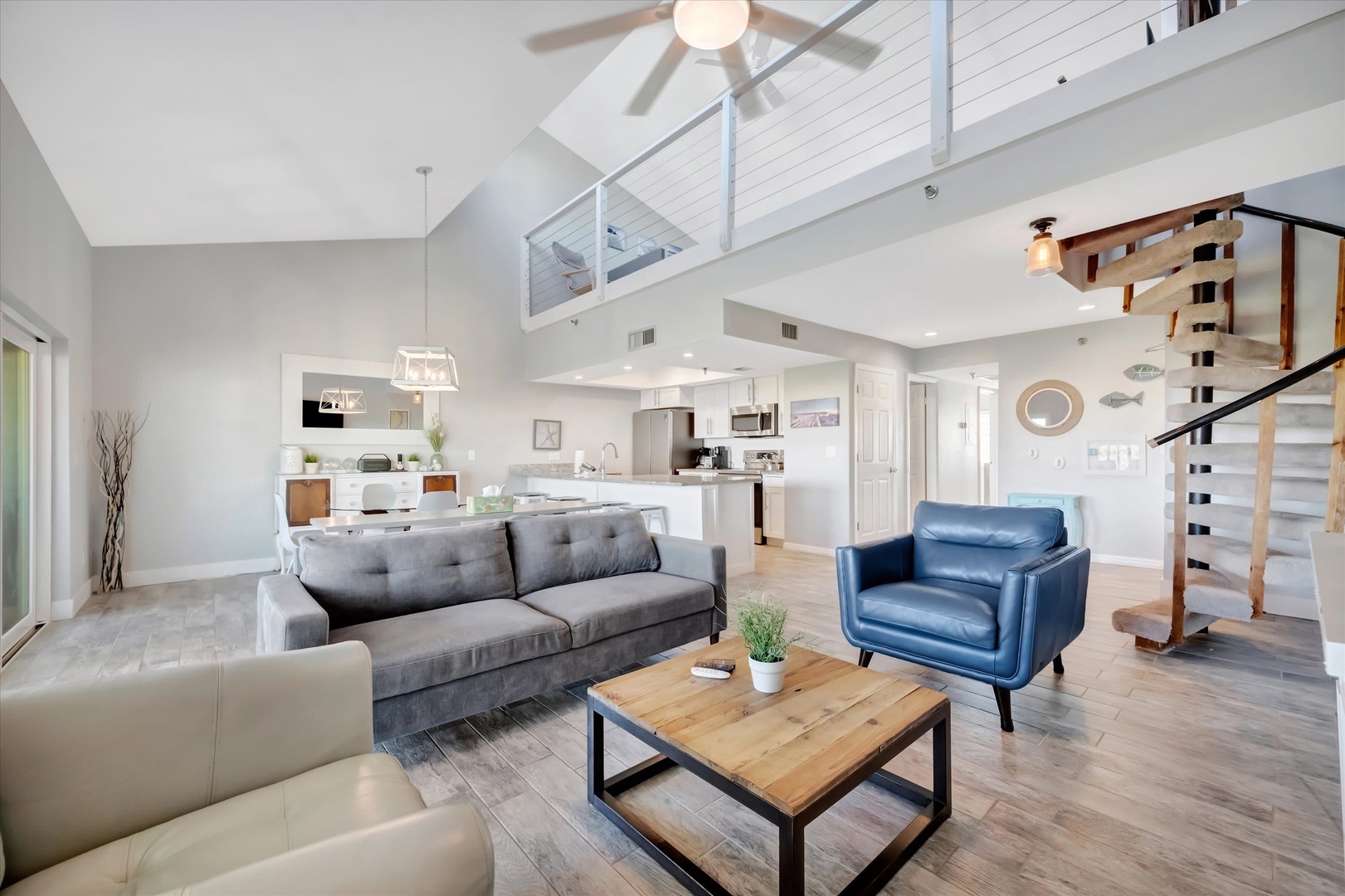 Bright, open living space with soaring ceilings, modern design, stylish seating, well-equipped kitchen, and airy loft—the perfect home away from home.