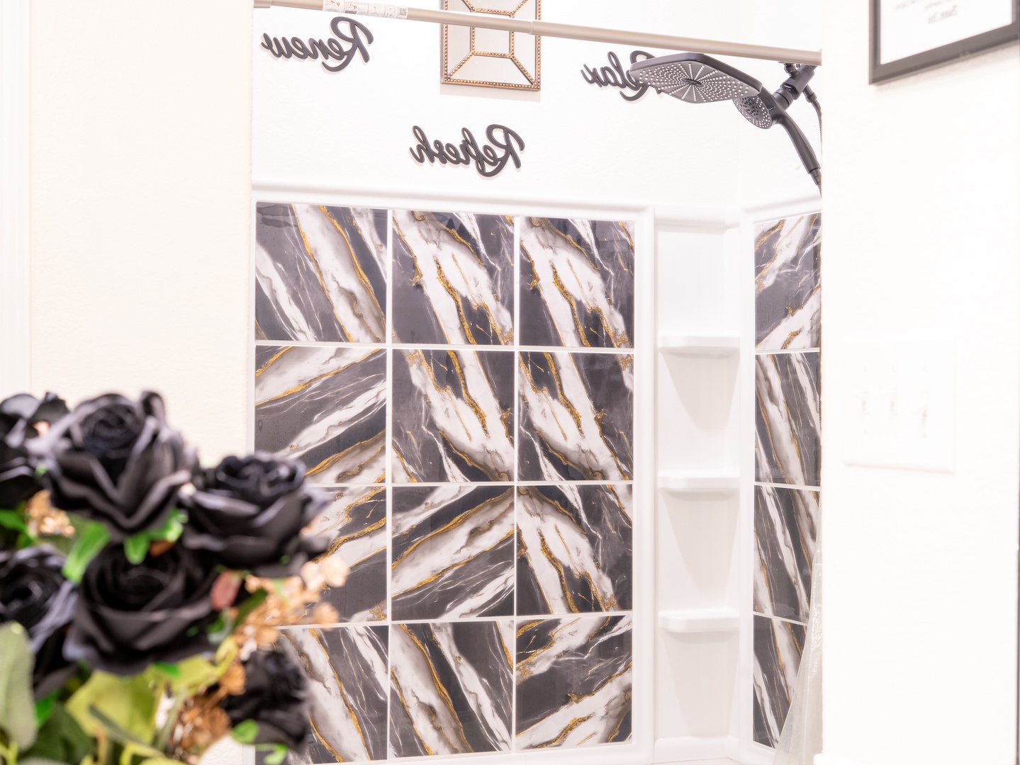 Chic marble-patterned tile brings modern luxury to your bathroom, where soft lighting and thoughtful touches create an elegant space to refresh and unwind.
