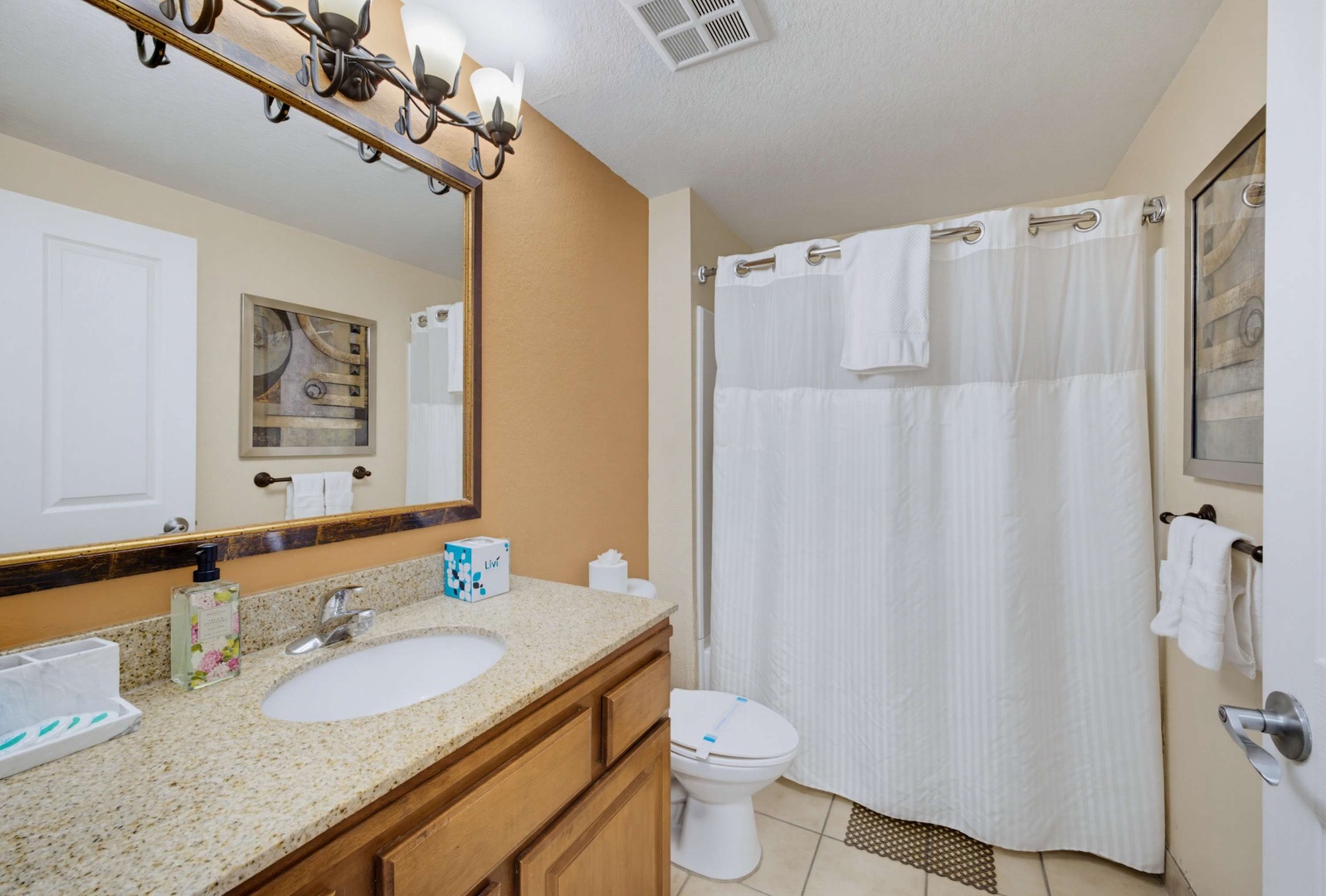 Step into your private bathroom with its warm tones and fresh towels ready for you. The spacious vanity and well-lit mirror create a welcoming retreat where you can unwind after your adventures.