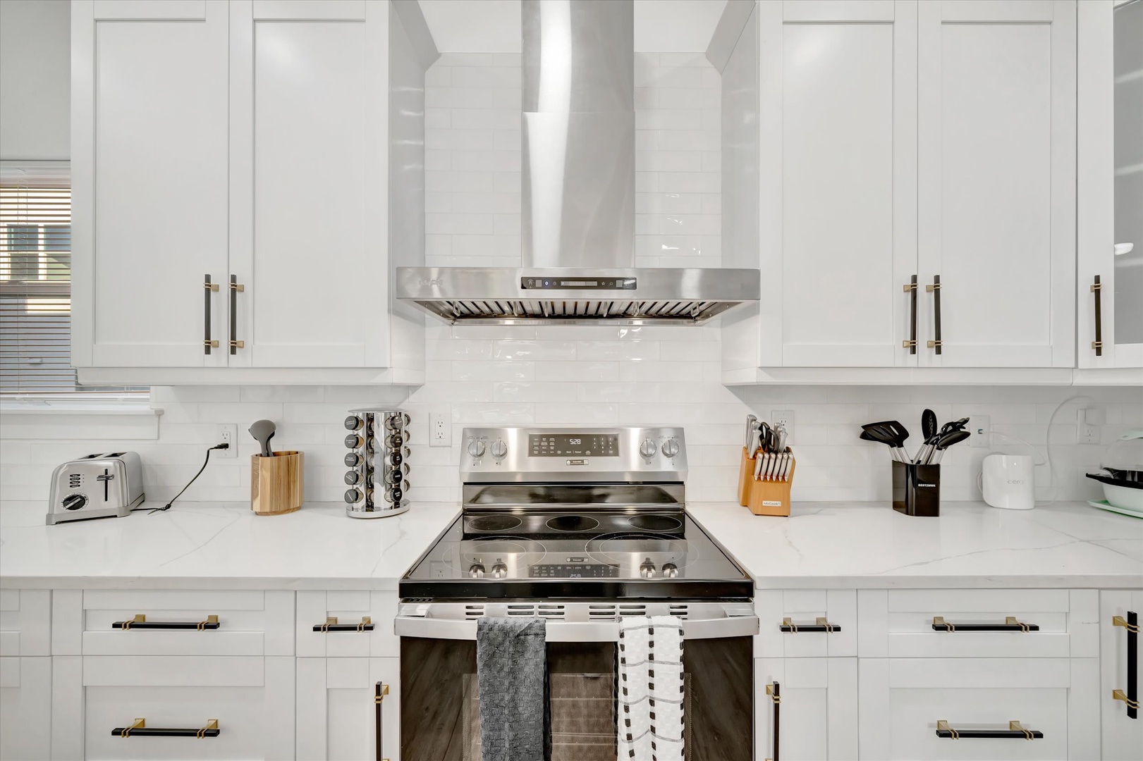 Your fully equipped kitchen sparkles with stainless steel appliances and bright white cabinetry, ready for you to prepare home-cooked meals during your stay.