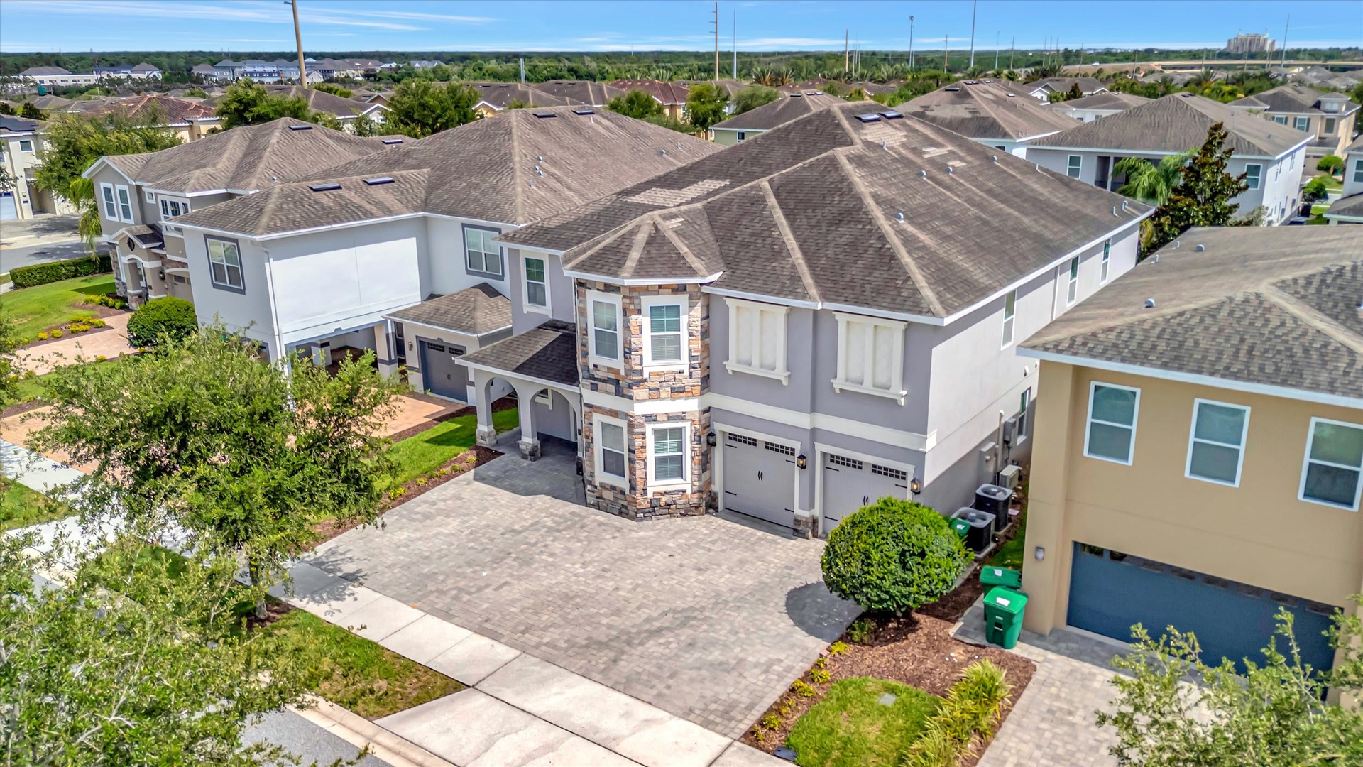 Aerial view of the property nestled within a residential neighborhood, showcasing spacious curb appeal and ample parking.