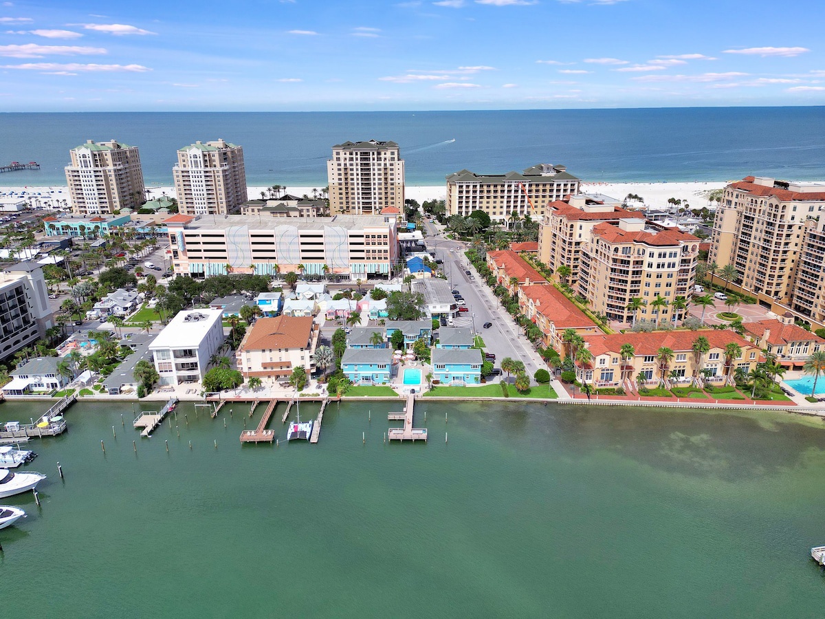 This beachfront community features coastal architecture with private marina access and pristine sandy shores along calm turquoise waters, creating an ideal vacation setting.