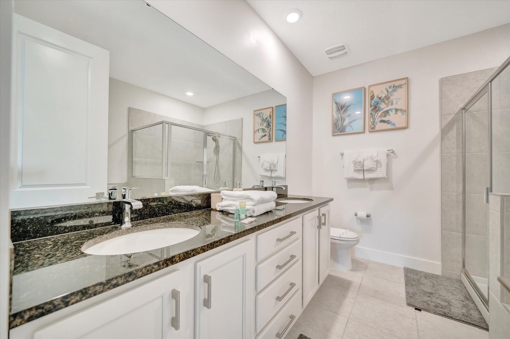 Step into your spa-like ensuite with dual vanities, a spacious walk-in shower, and fresh towels ready for your arrival. Every detail invites relaxation.