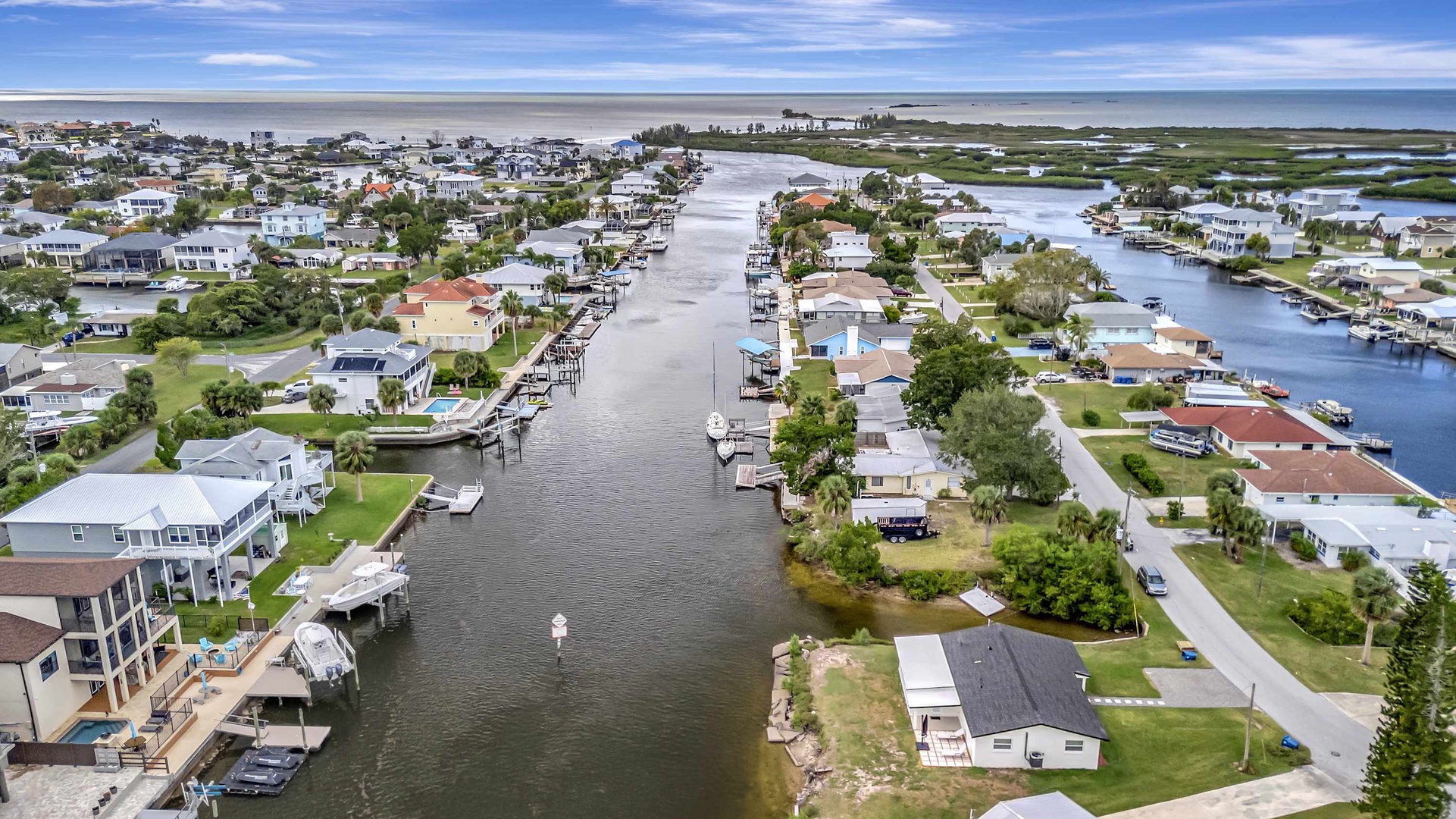 A coastal waterfront community with canal access, private docks, and ocean views stretches along the shoreline.