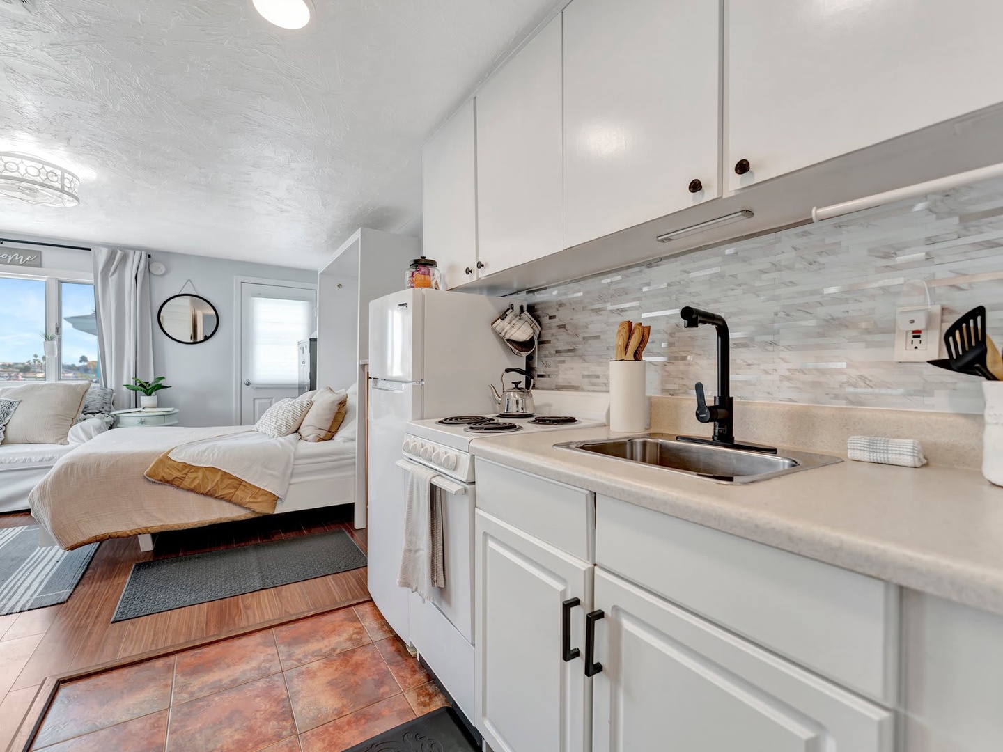 Step into your bright, open studio where comfort meets convenience. The stylish kitchen features modern appliances and a sleek backsplash, while your cozy living space invites you to unwind after a day of exploring.