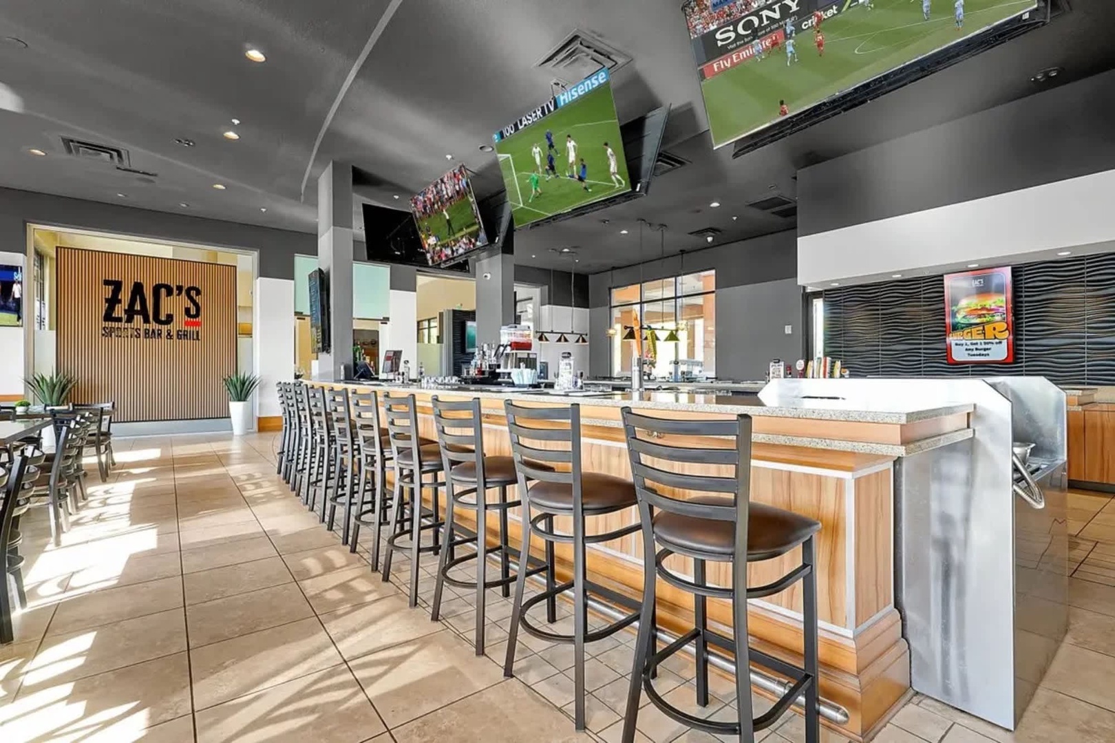A welcoming on-site bar area where you can catch the game on multiple screens while enjoying drinks and casual dining in a bright, modern space.