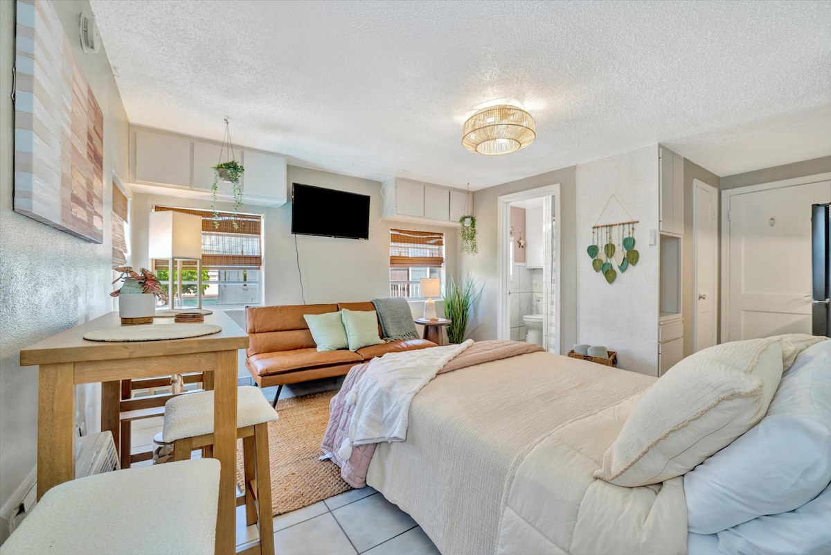 Your cozy studio welcomes you with soft natural light, a plush bed dressed in airy linens, and a comfortable lounge area—everything you need to unwind after exploring the area.