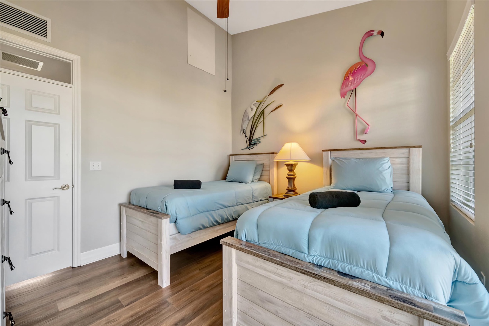 Drift off in this cheerful twin bedroom where soft blue linens and playful coastal decor create your perfect beach-inspired retreat.