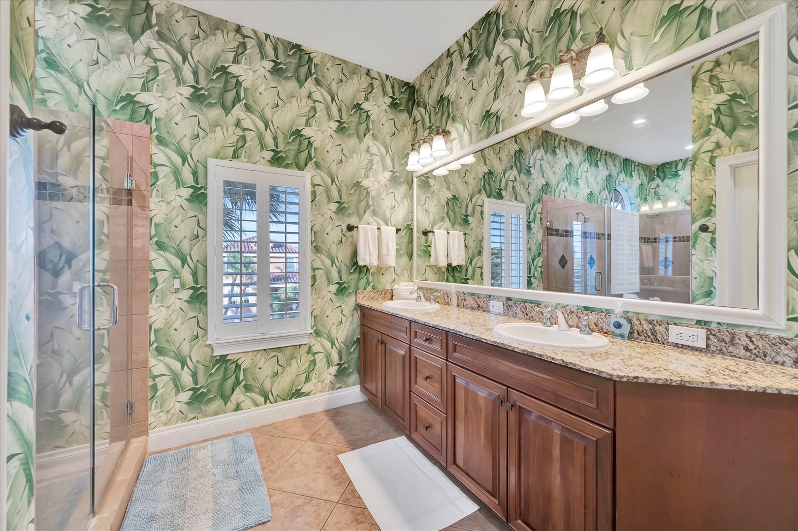 Step into your spa-inspired bathroom with vibrant tropical wallpaper, a luxurious walk-in shower, and a spacious double vanity where you'll enjoy getting ready each day.
