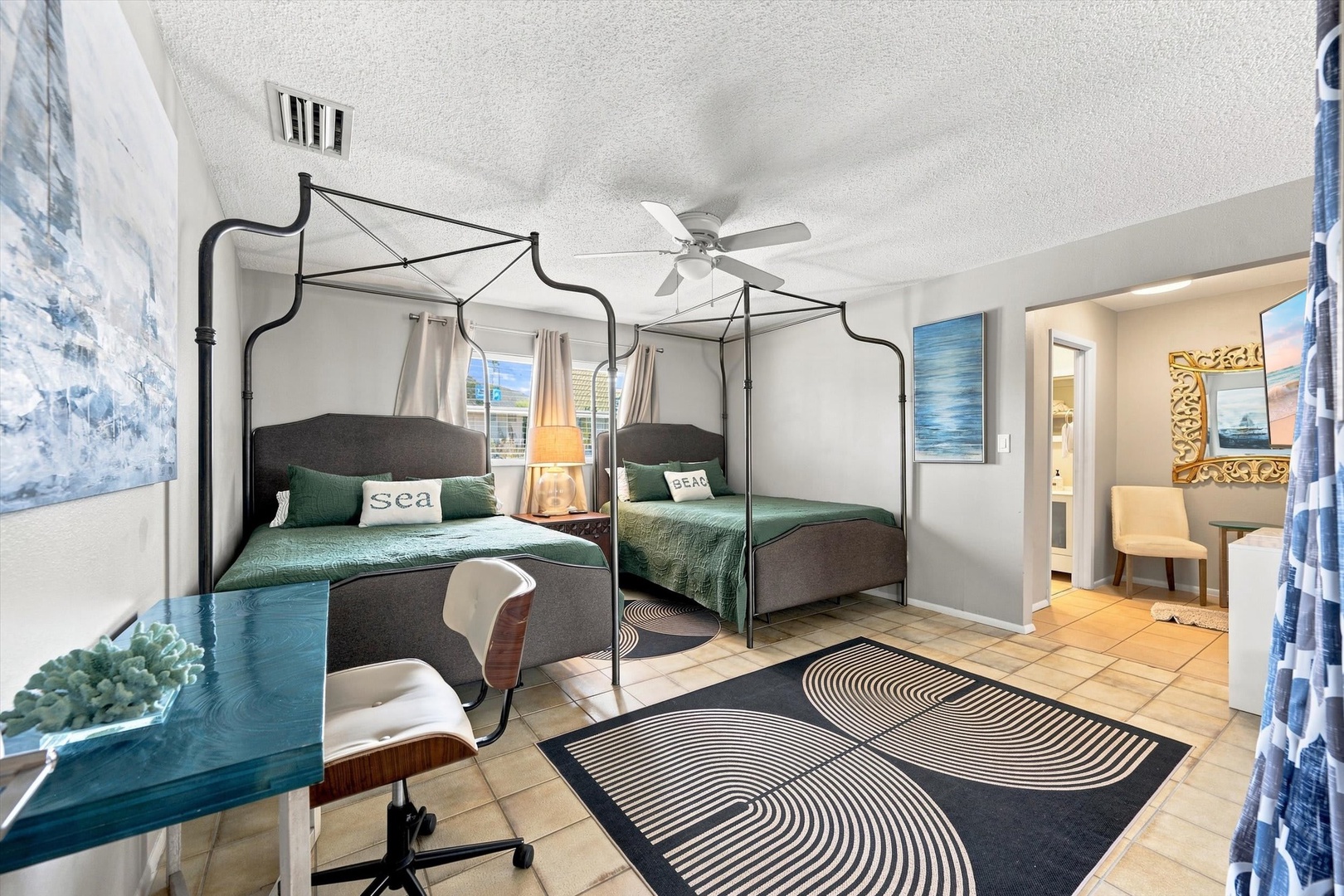 Drift off beneath the elegant canopy bed while a gentle ceiling fan keeps your coastal retreat comfortable—your private ocean-inspired sanctuary awaits.