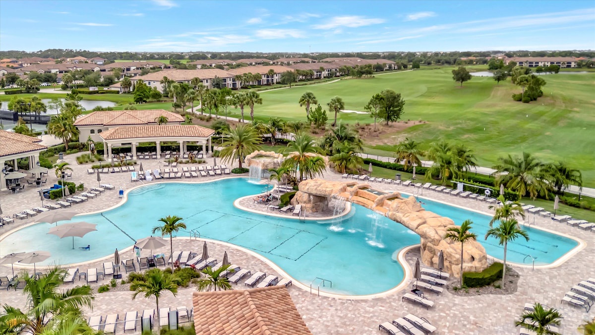 This resort-style community features a stunning lagoon-style pool with waterfalls and tropical landscaping, overlooking manicured golf course fairways and surrounding residential neighborhoods.