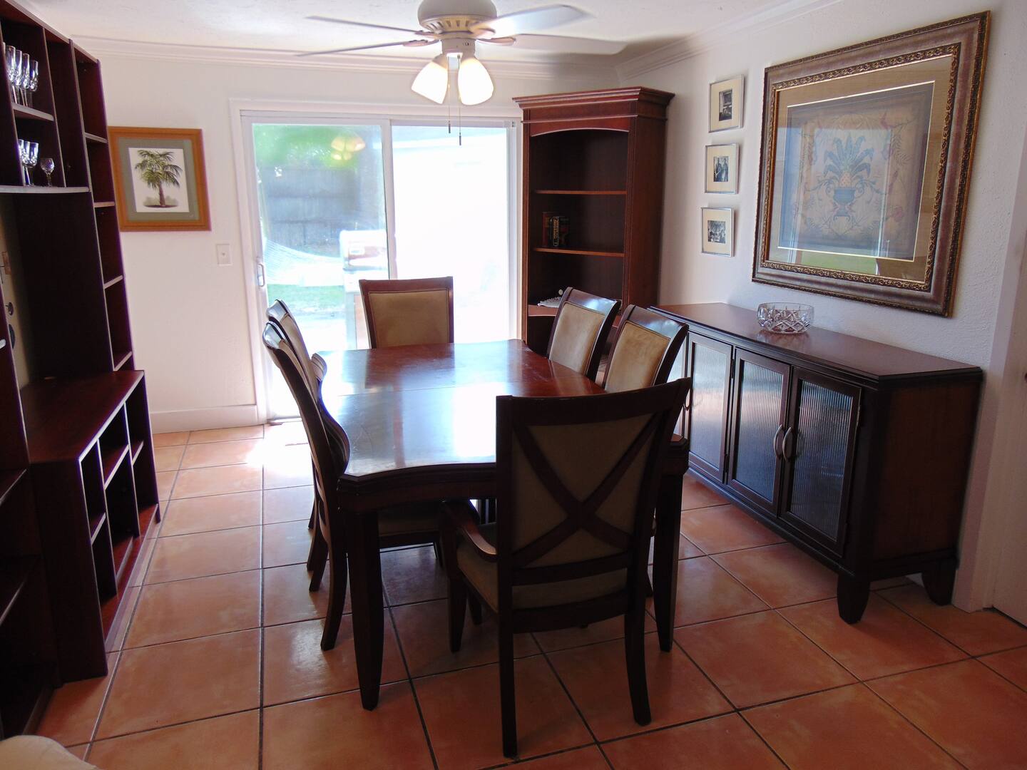 Gather around the elegant dining table for meals and conversation, with a bright outdoor view and ample storage for your stay.