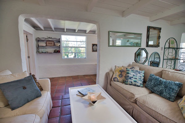 Sink into soft sofas and eclectic décor in your inviting living space, where whitewashed walls and warm terra-cotta floors create a calming retreat perfect for unwinding.