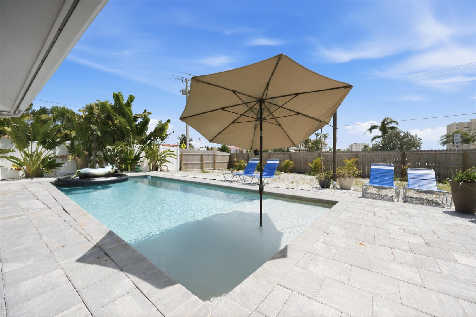 Step outside to your private pool surrounded by tropical palms and comfortable loungers, perfect for soaking up the sun in your own backyard oasis.
