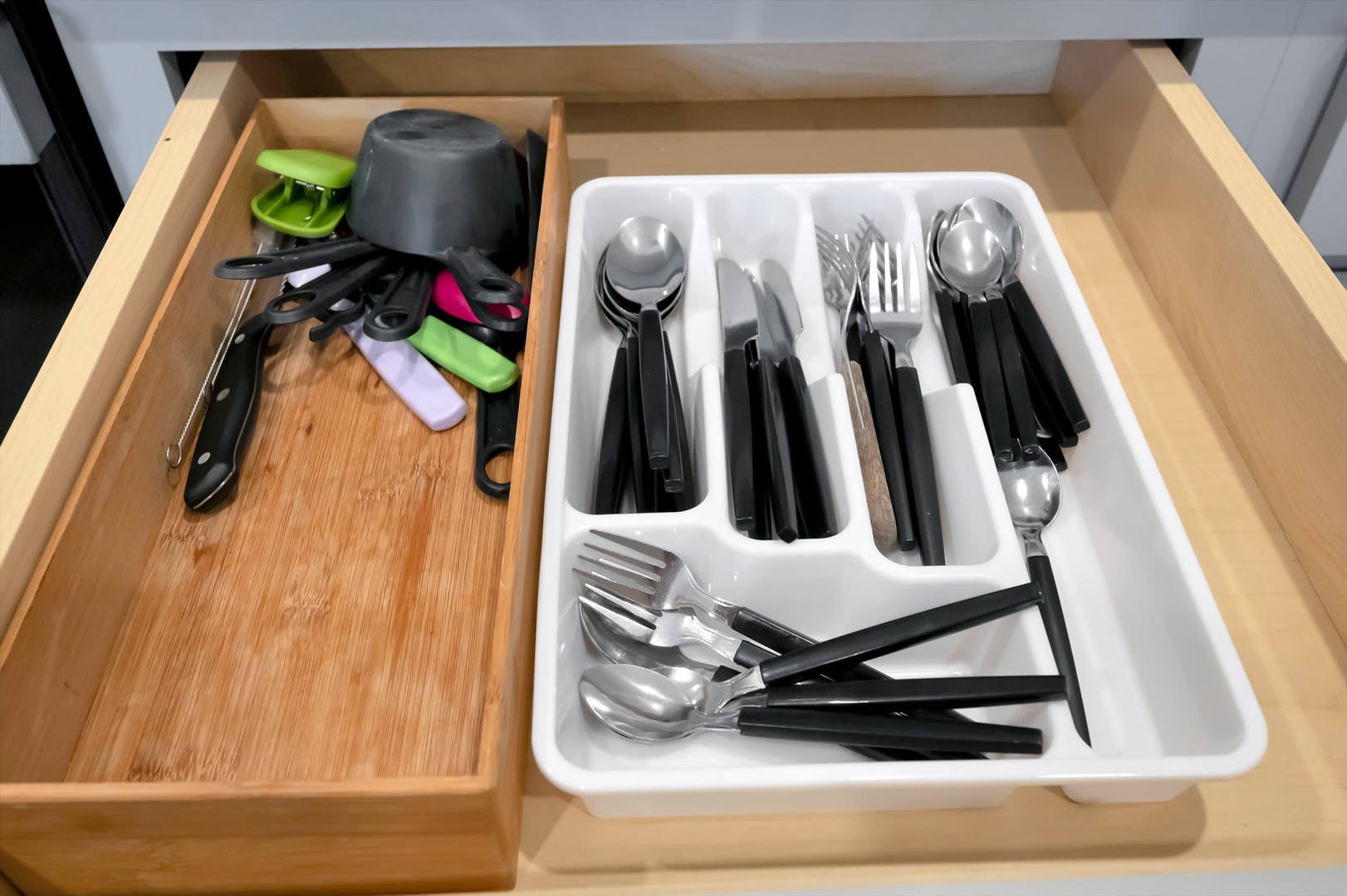 Your kitchen drawer is stocked with everything you need—sleek cutlery, handy utensils, and helpful gadgets all neatly organized for easy cooking and dining.