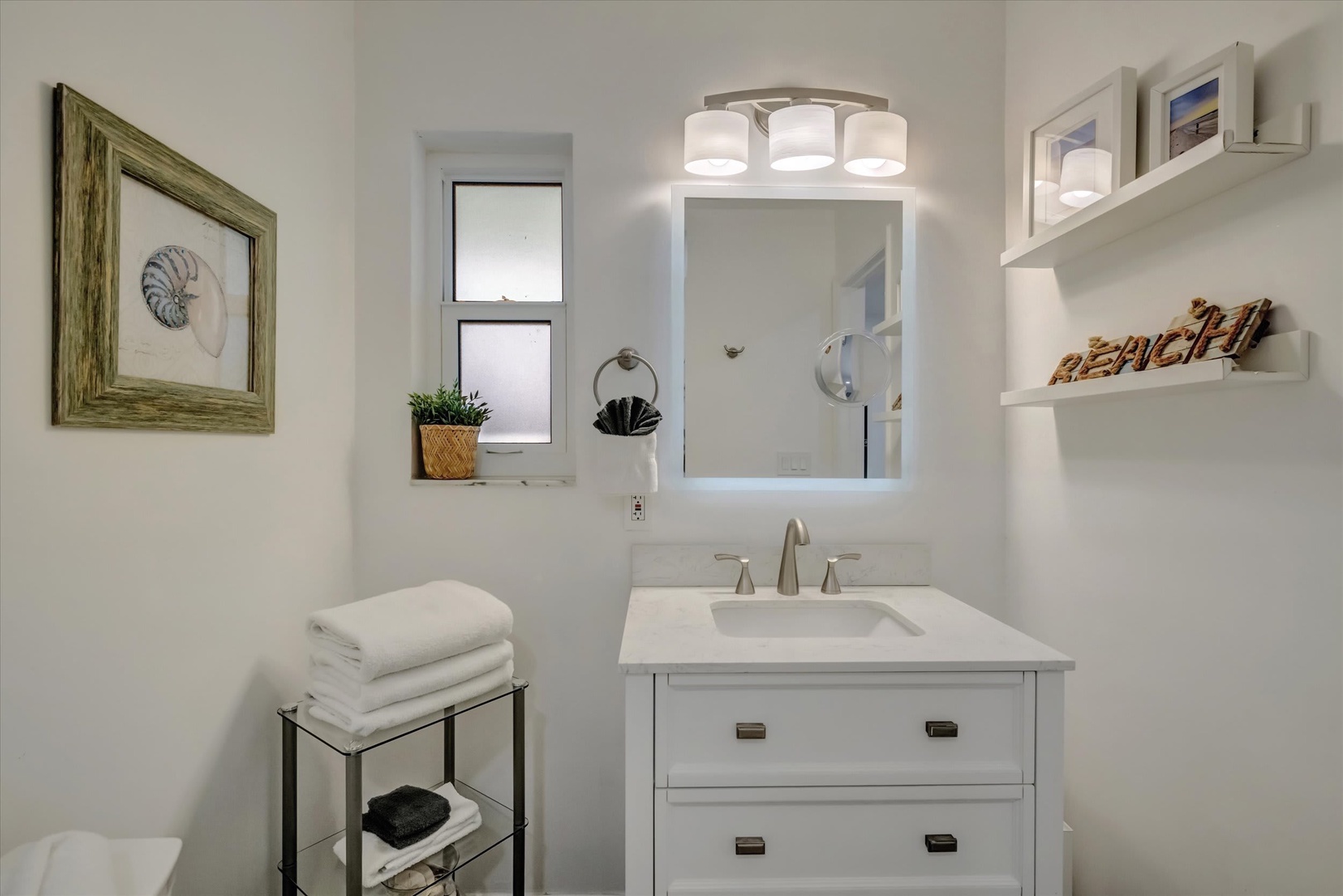 Step into your serene coastal-themed bathroom, where crisp white tones and beach-inspired décor create a peaceful retreat for your morning refresh.