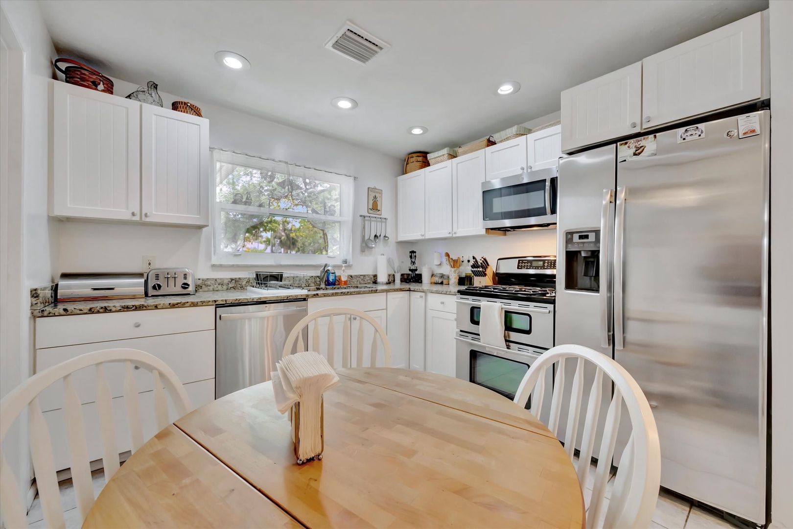 Your bright, welcoming kitchen is ready for you to cook up a feast. White cabinetry, stainless appliances, and a spacious dining table make this the perfect spot to gather and unwind.