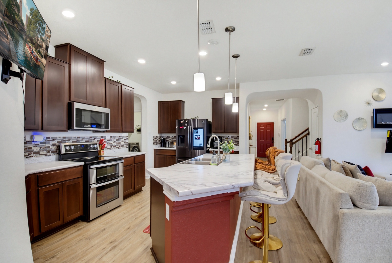 Gather in your spacious, open-concept kitchen with modern appliances, a large marble island for meal prep, and a cozy living area just steps away—perfect for creating and sharing meals together.
