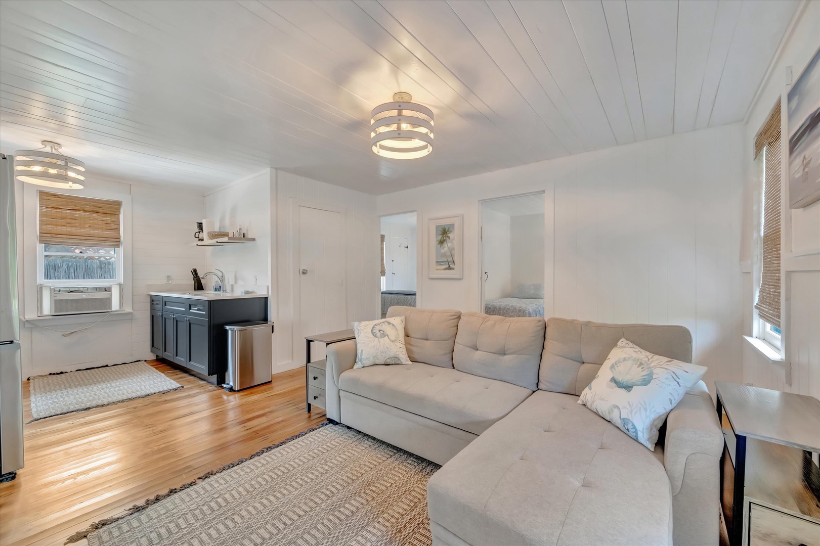 Relax into this bright, airy living space with comfortable seating and a coastal feel. The open layout connects you to a sleek kitchenette, perfect for unwinding after your adventures.