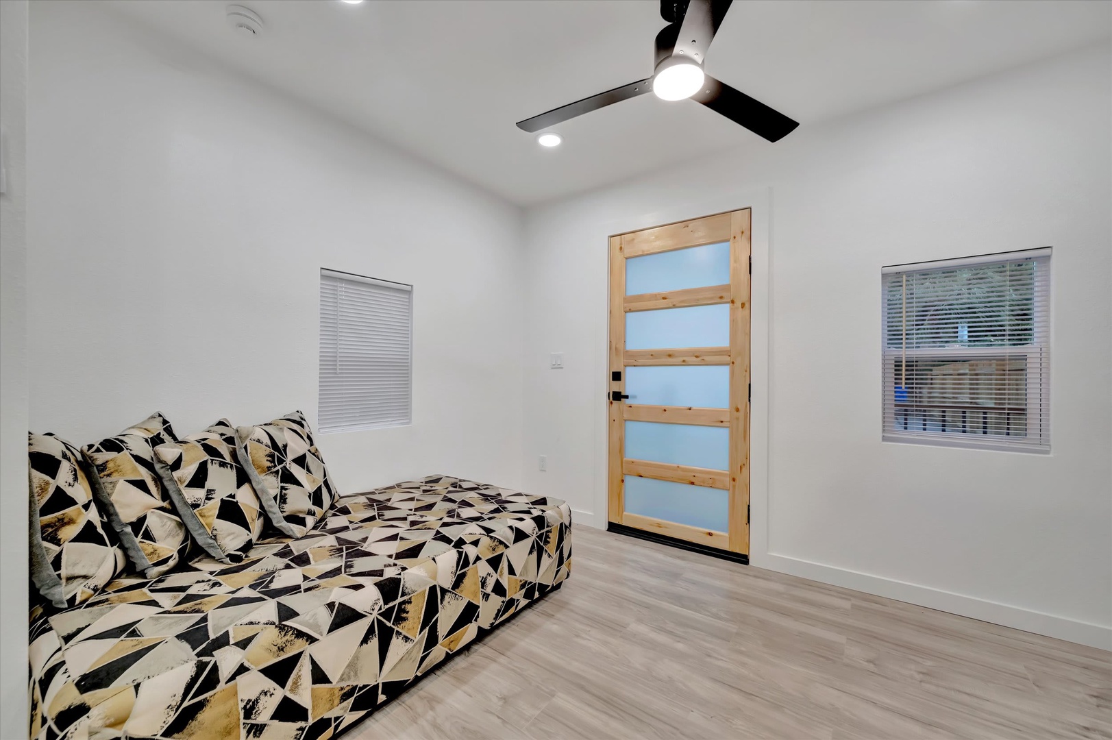 Unwind in your bright, modern space with sleek ceiling fan and stylish geometric seating—perfect for relaxing after a day of exploring.