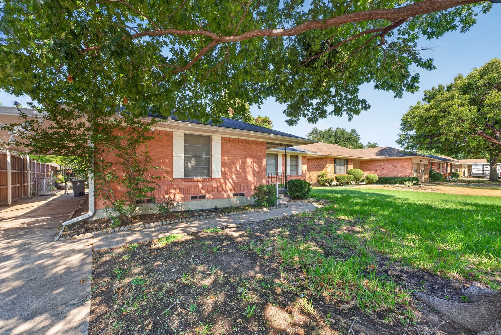 Charming red-brick home in a peaceful neighborhood, with mature shade trees, easy parking, and a welcoming front porch ideal for morning coffee.