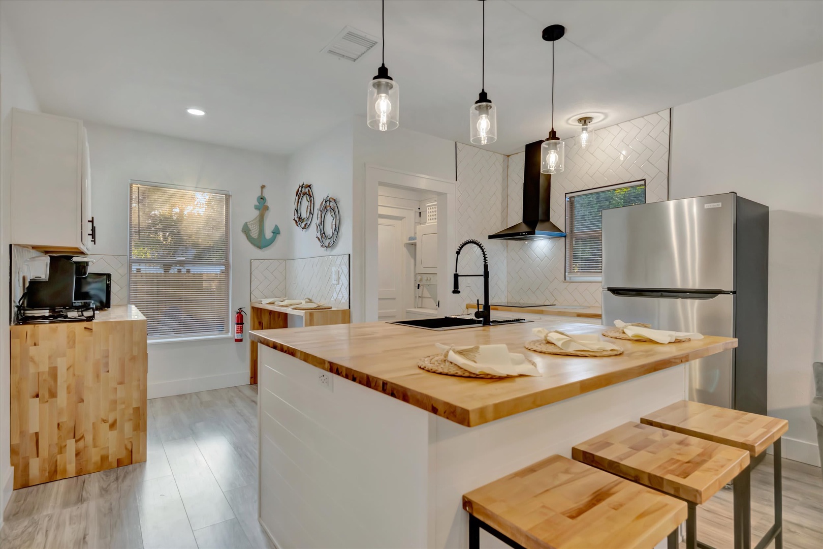 Step into your bright coastal kitchen, where butcher-block countertops and nautical charm create the perfect space for preparing seaside meals together.