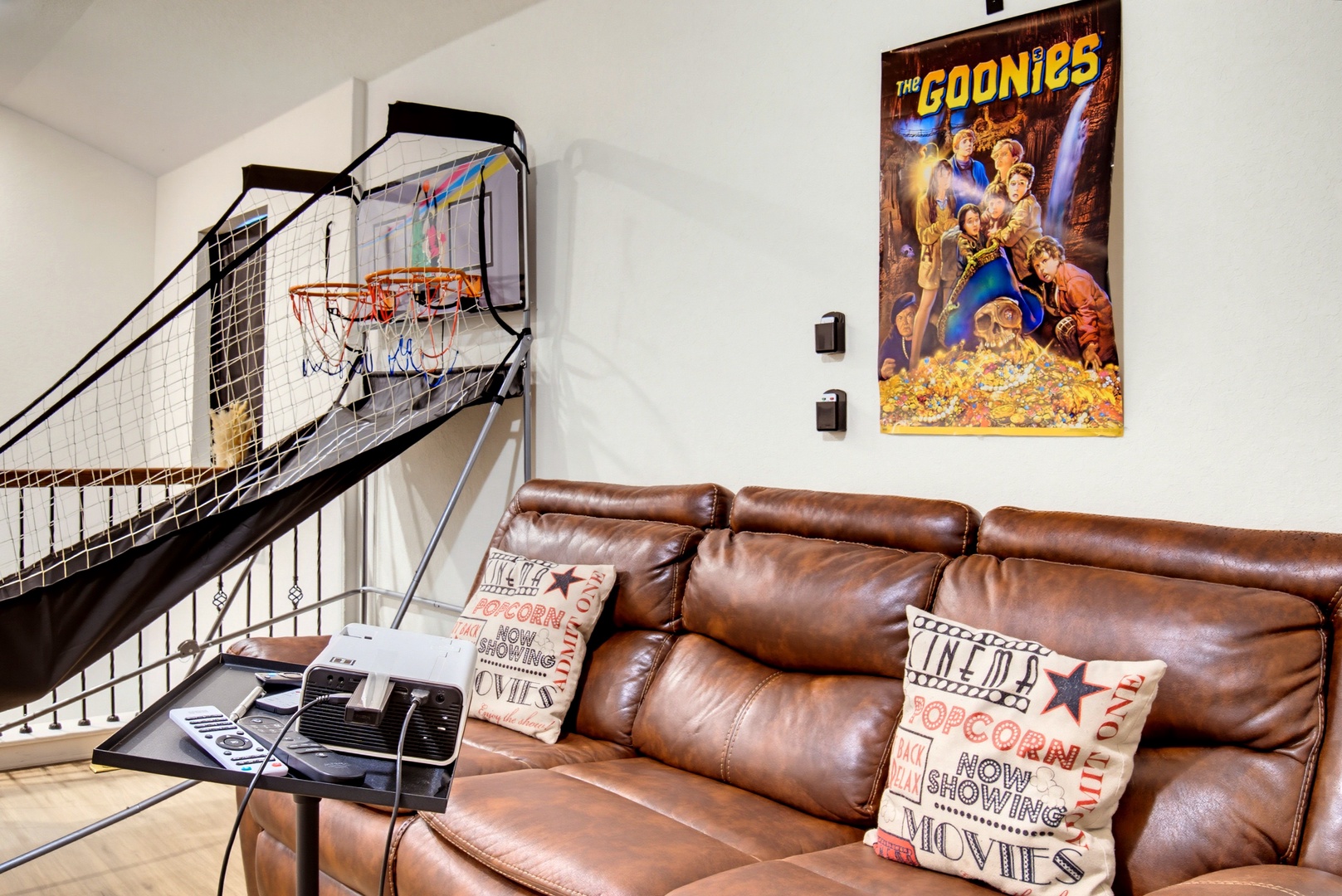 Challenge friends to a game in your entertainment space, complete with a basketball hoop, cozy leather seating, and movie-themed decor for laid-back fun.
