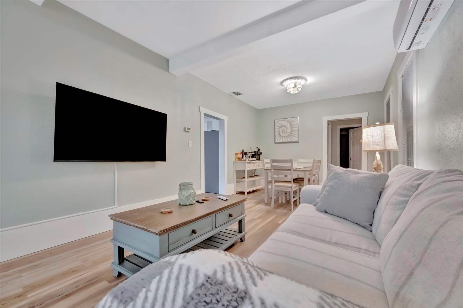 Relax in this bright, open living space with soft coastal touches. Sink into the plush sectional after a day of adventure, enjoy meals at your cozy dining table, or unwind with your favorite show on the wall-mounted TV.
