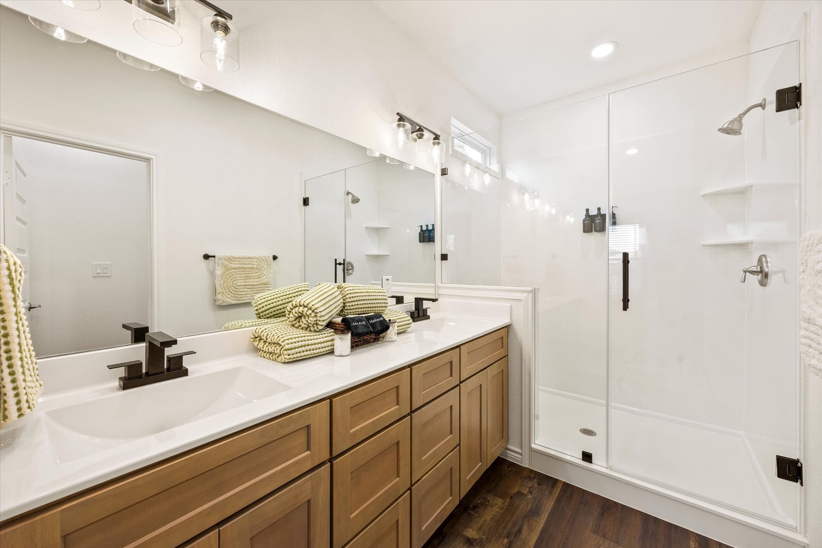 Step into your beautifully appointed bathroom with dual vanities, spacious walk-in shower, and warm wood finishes that make getting ready feel like a spa experience.