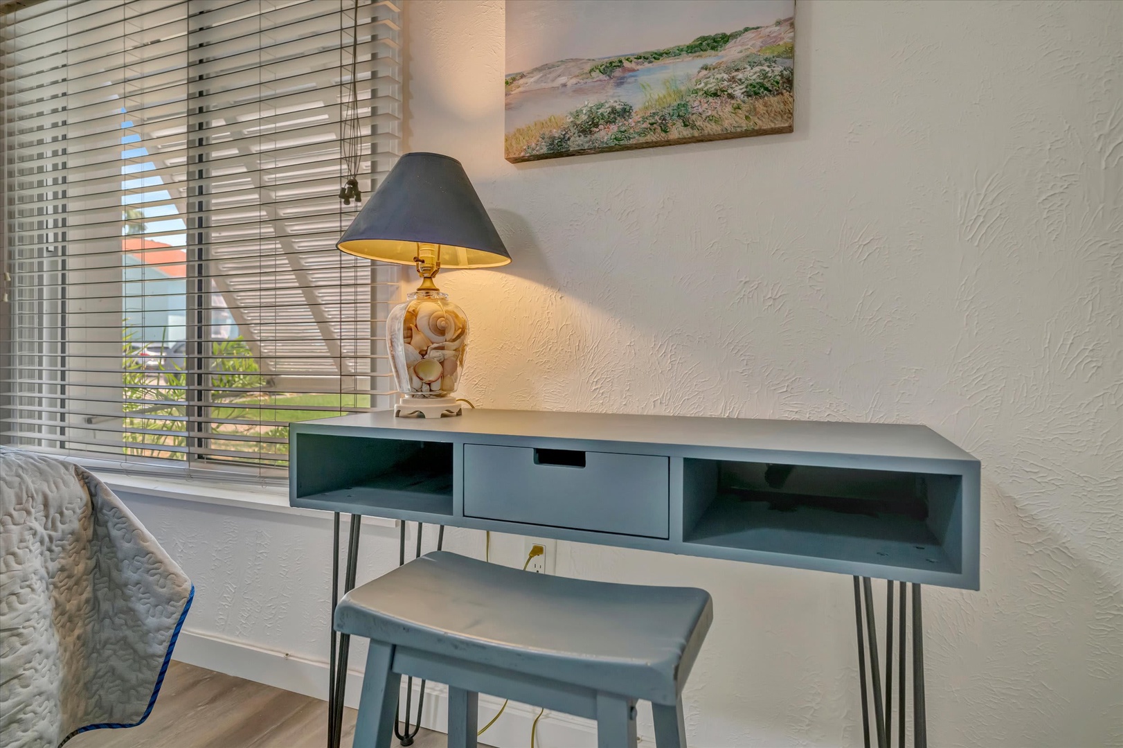 Settle in at your modern desk space, where warm natural light and coastal artwork create the perfect spot for planning your next adventure.