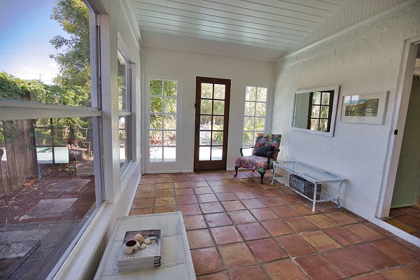 Step into your bright, airy sunroom where terracotta tiles warm the space and garden views greet you through every window. Curl up with a book in the cozy armchair or simply unwind as natural light fills the room.