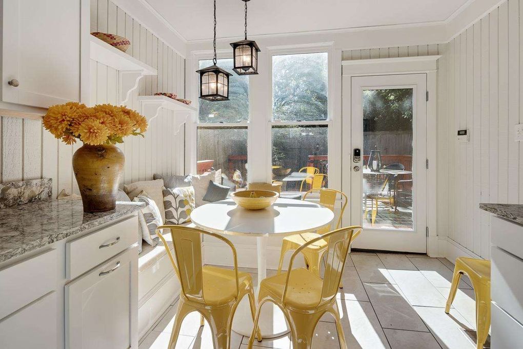 Gather around this sunny breakfast nook where morning light spills through French doors, illuminating cheerful yellow chairs and fresh flowers. Step outside to your private patio for your coffee ritual.