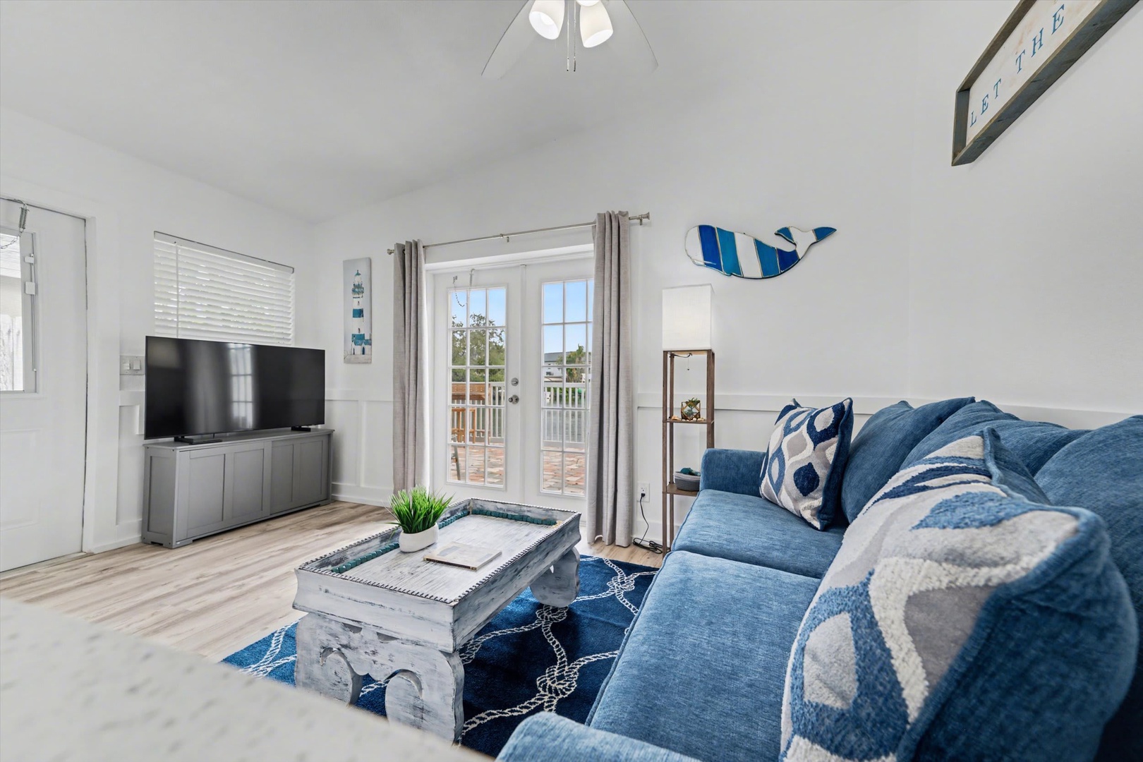 Sink into plush blue seating and let coastal charm wash over you. Your private balcony beckons through French doors, ready to frame your morning coffee moment.