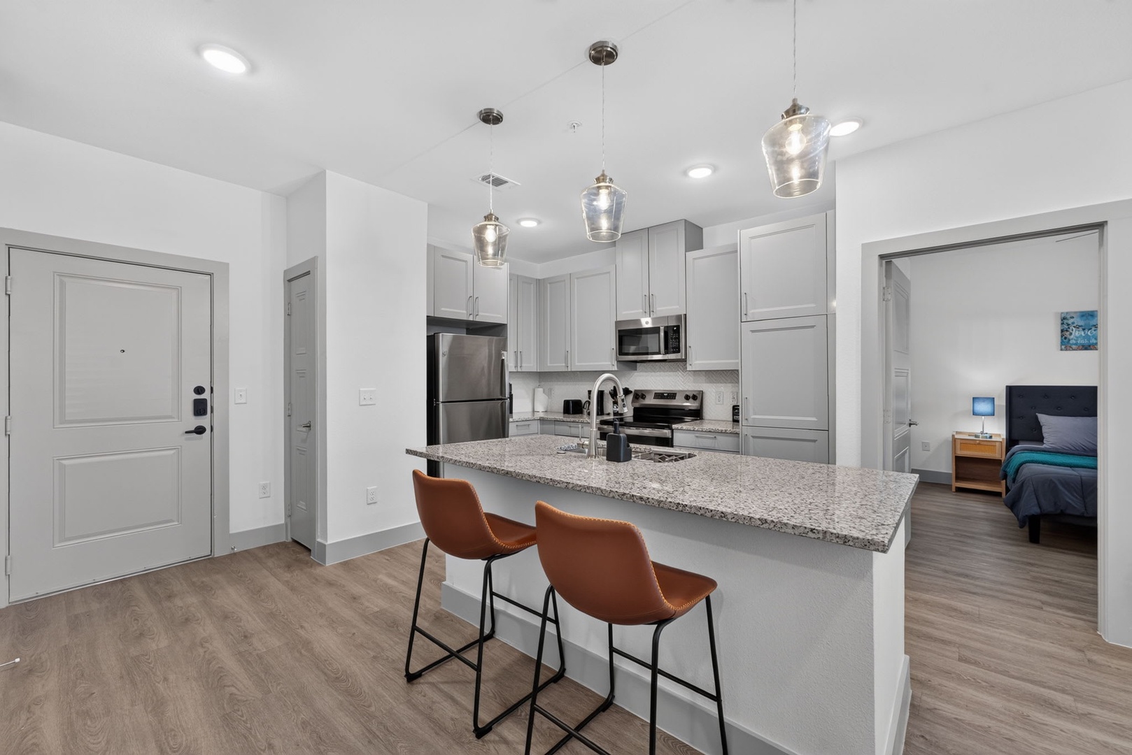 Your bright, modern open-concept space feels instantly inviting with its contemporary kitchen island ready for morning coffee or evening conversations, while stylish pendant lights add a warm glow throughout.