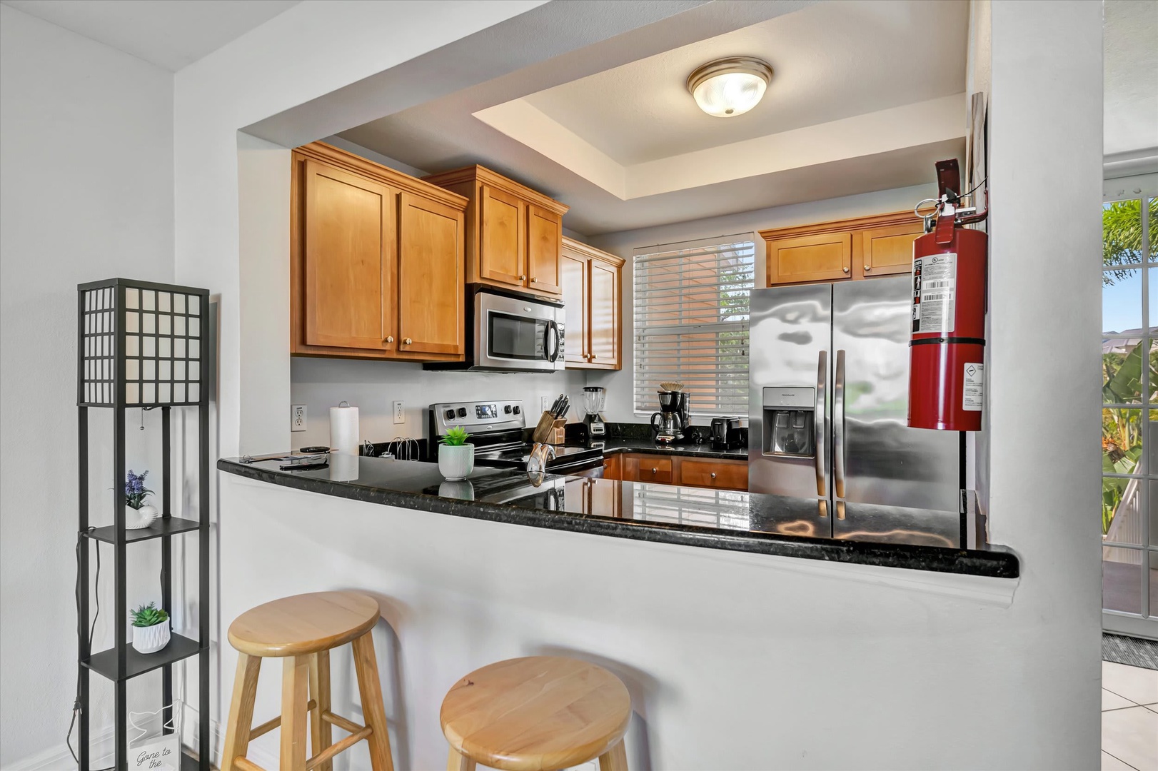 Your fully equipped kitchen features sleek granite countertops, stainless steel appliances, and a convenient breakfast bar—perfect for whipping up morning coffee or preparing meals during your stay.