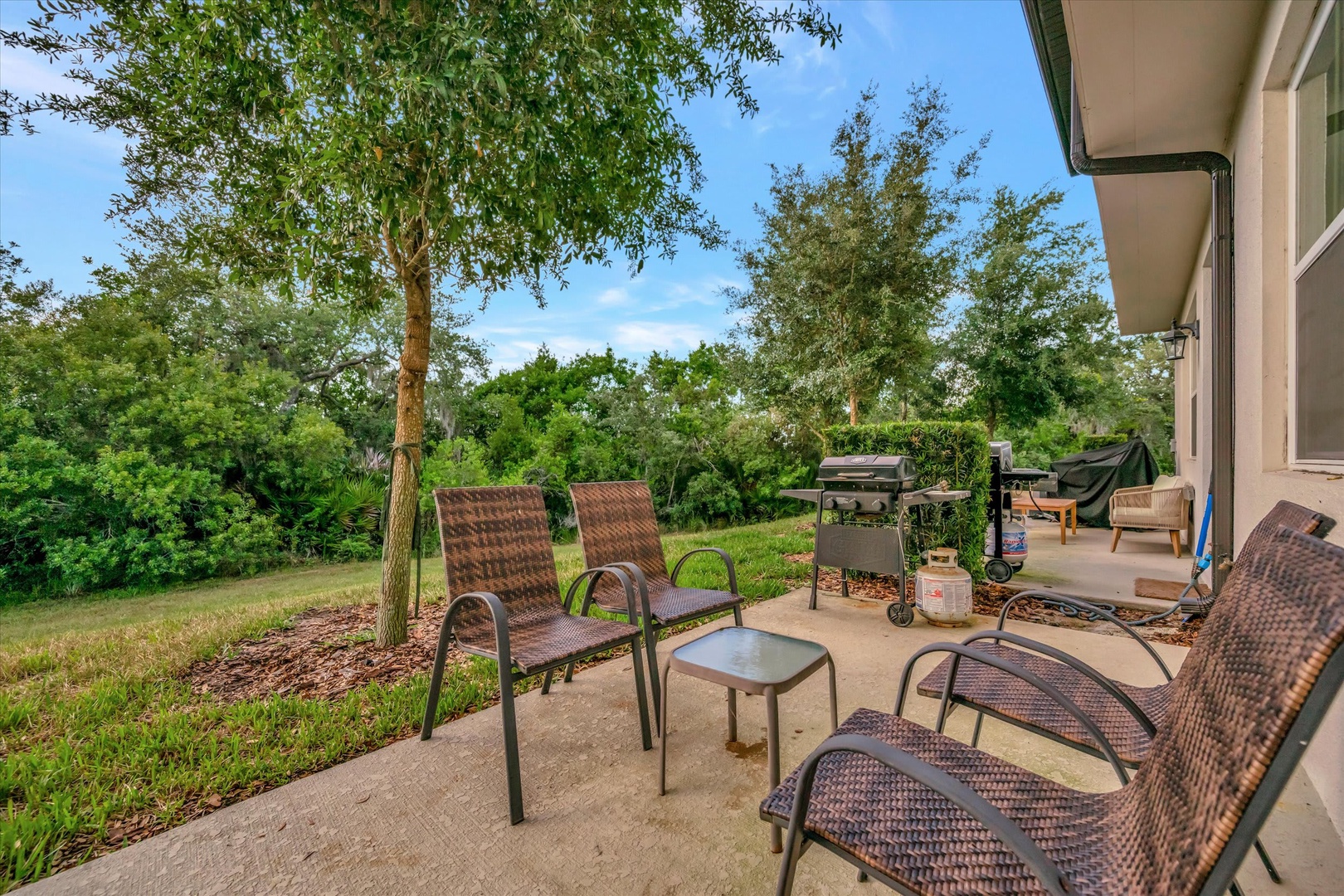 Step outside to your private patio where comfortable lounge chairs await beneath towering trees. Fire up the grill for an afternoon cookout, relax with a cold drink, and soak in the peaceful natural surroundings—your perfect outdoor escape.