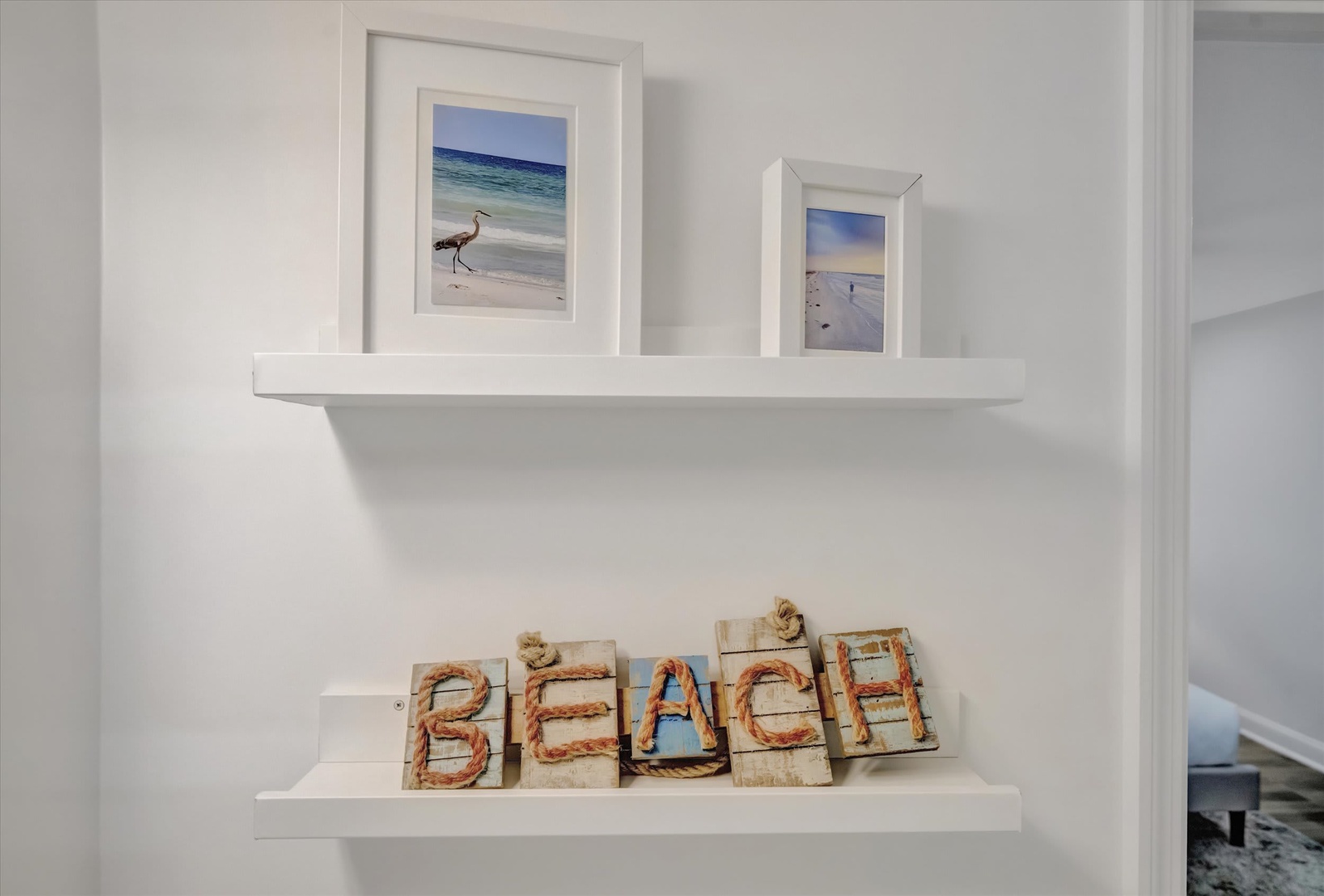 Coastal charm meets cozy details—framed beach memories and rope-lettered décor set a relaxed, seaside tone the moment you step inside.