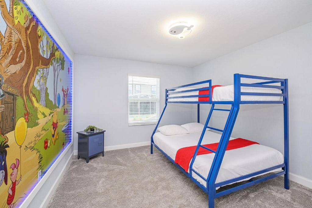 Your little ones will love this cheerful bunk room, complete with a fun Winnie the Pooh mural and bright blue beds with cozy red and white linens.