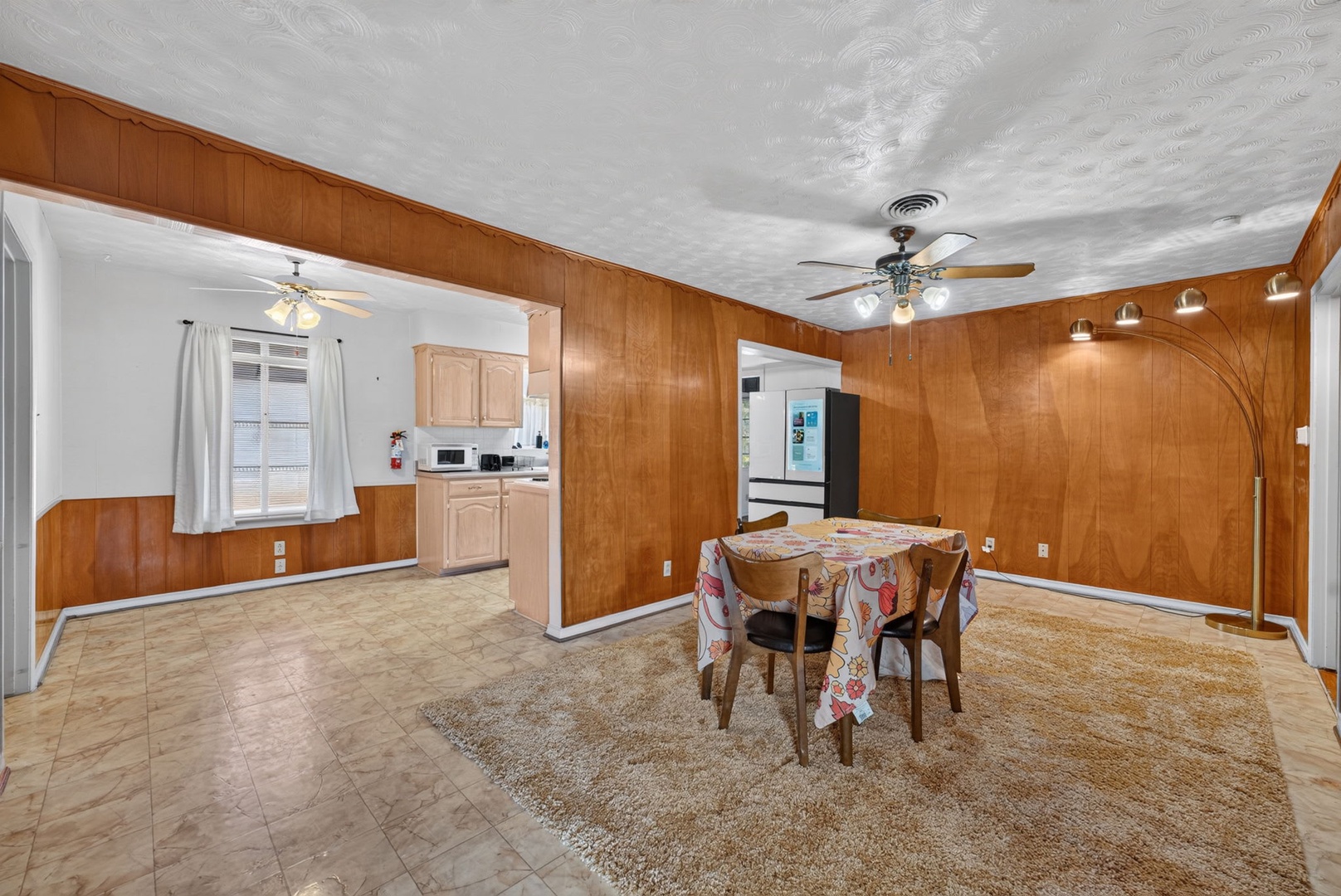 Enjoy your meals in this spacious dining area, complete with warm wood paneling, comfortable seating, and an open flow to the kitchen. Perfect for gathering after a day of exploring.