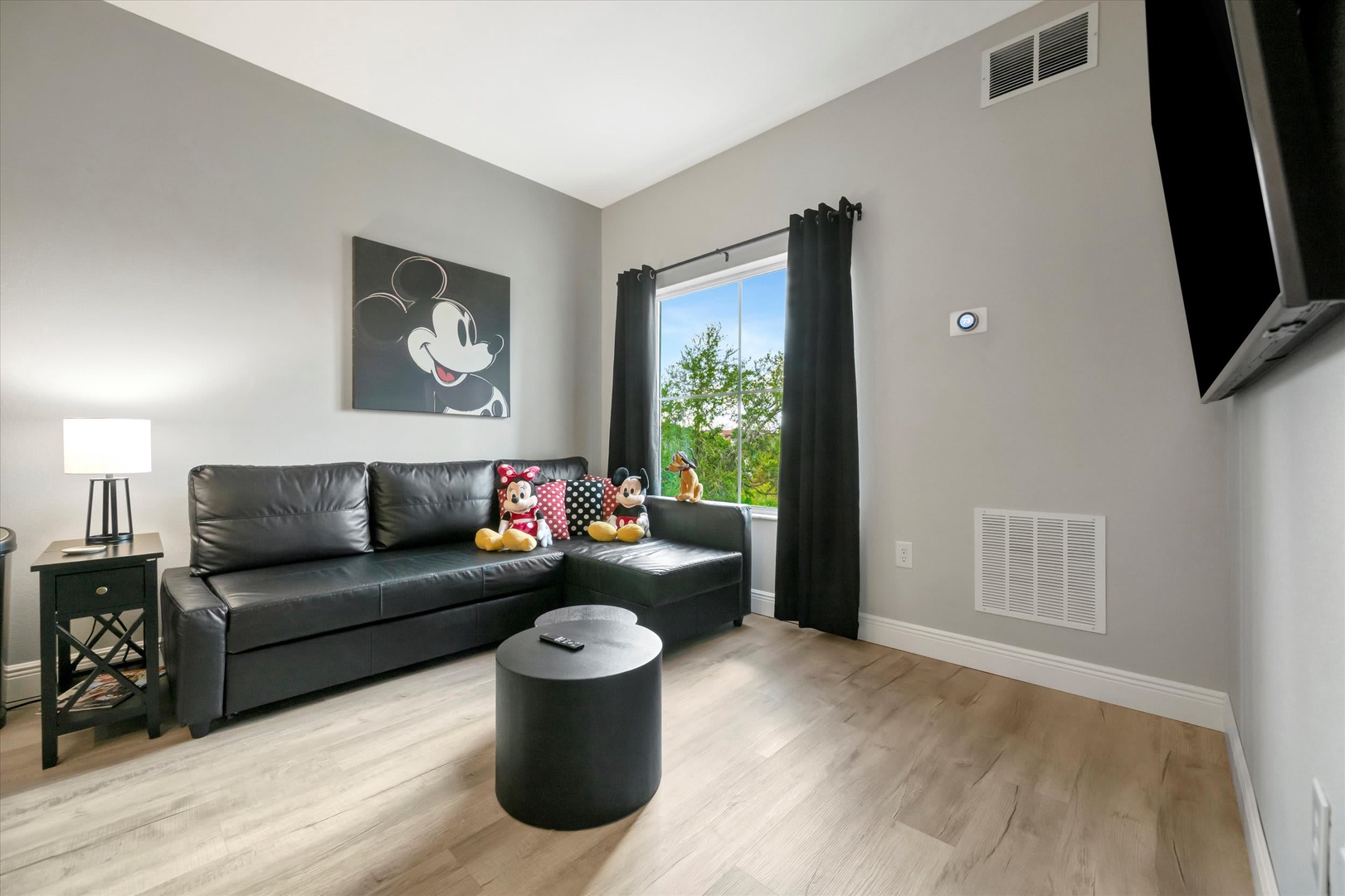 Settle into your cozy living space with vaulted ceilings and natural light streaming through the window. The sleek sectional and modern finishes create a welcoming retreat after a day of adventure.