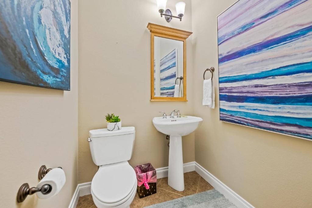Your private powder room offers a pedestal sink, polished fixtures, and coastal-inspired artwork that sets a serene tone for your stay.