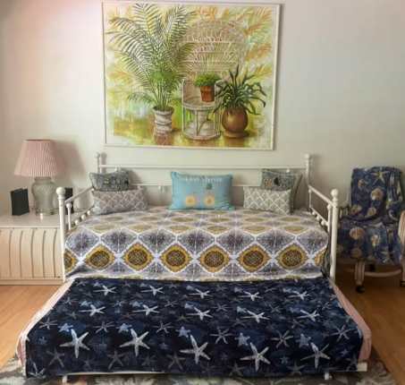 Your coastal retreat awaits with a charming daybed featuring a pull-out trundle for extra guests. Cheerful botanical artwork and plush seating create a bright, welcoming space where you can unwind after a day of exploring.