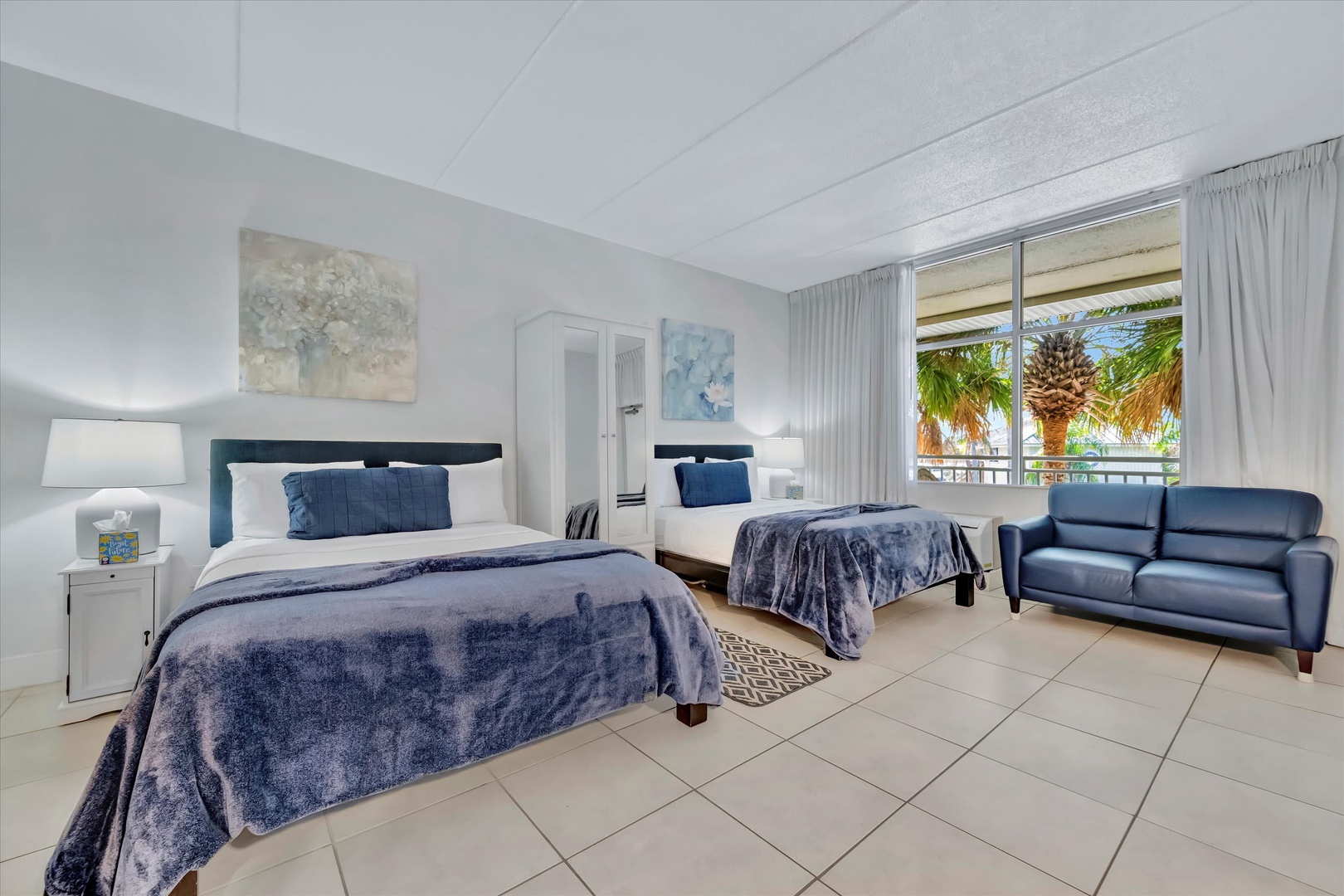 Sink into plush bedding and unwind in your spacious retreat, where soft blue tones and a cozy sofa invite you to relax after a day of adventure.