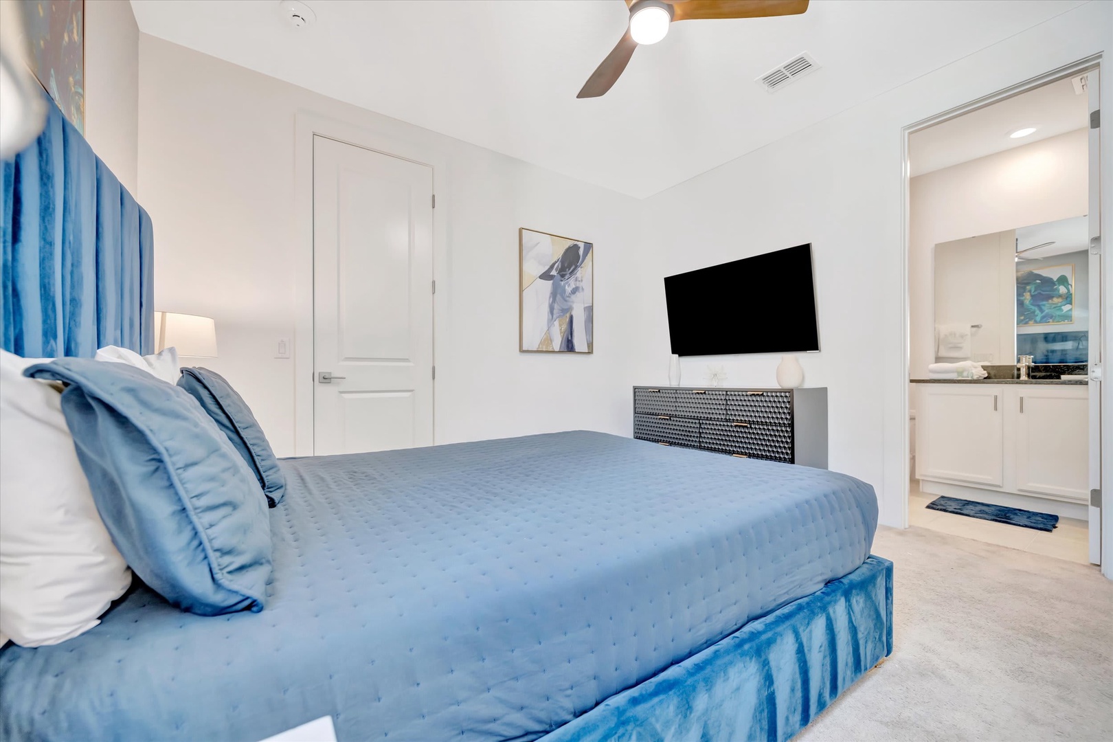 Sink into plush blue bedding and unwind in your serene retreat, complete with modern amenities and a private en-suite bathroom for ultimate comfort.