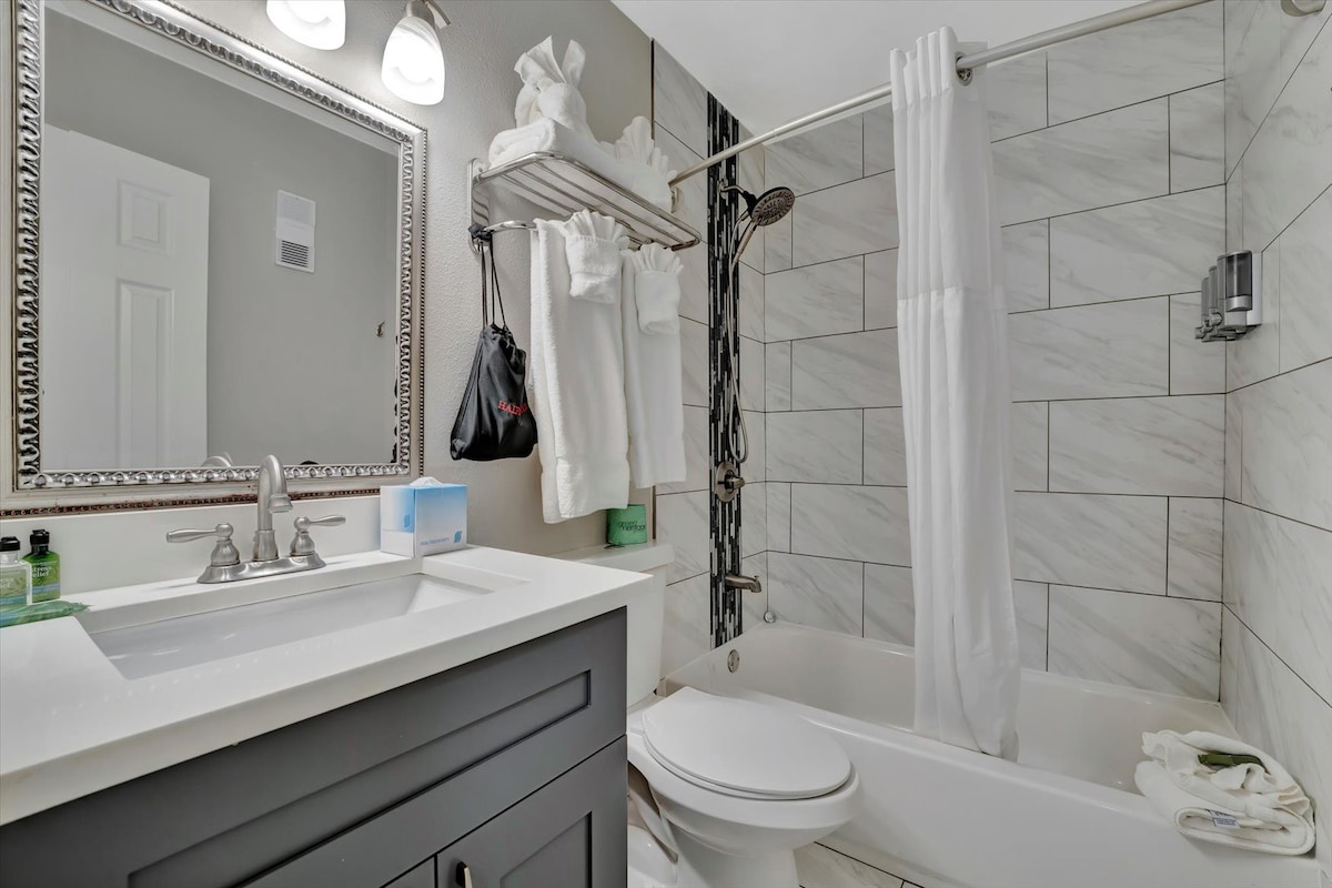 Step into your modern bathroom featuring marble-effect tile, a sleek vanity, and refreshing rainfall shower—everything you need to unwind after a day of adventure.