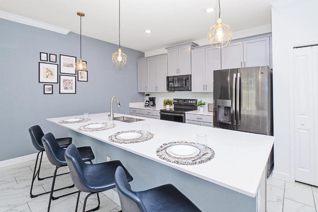 Gather around this spacious kitchen island with seating for four, where modern appliances and soft blue walls create your perfect space for morning coffee or evening meal prep.