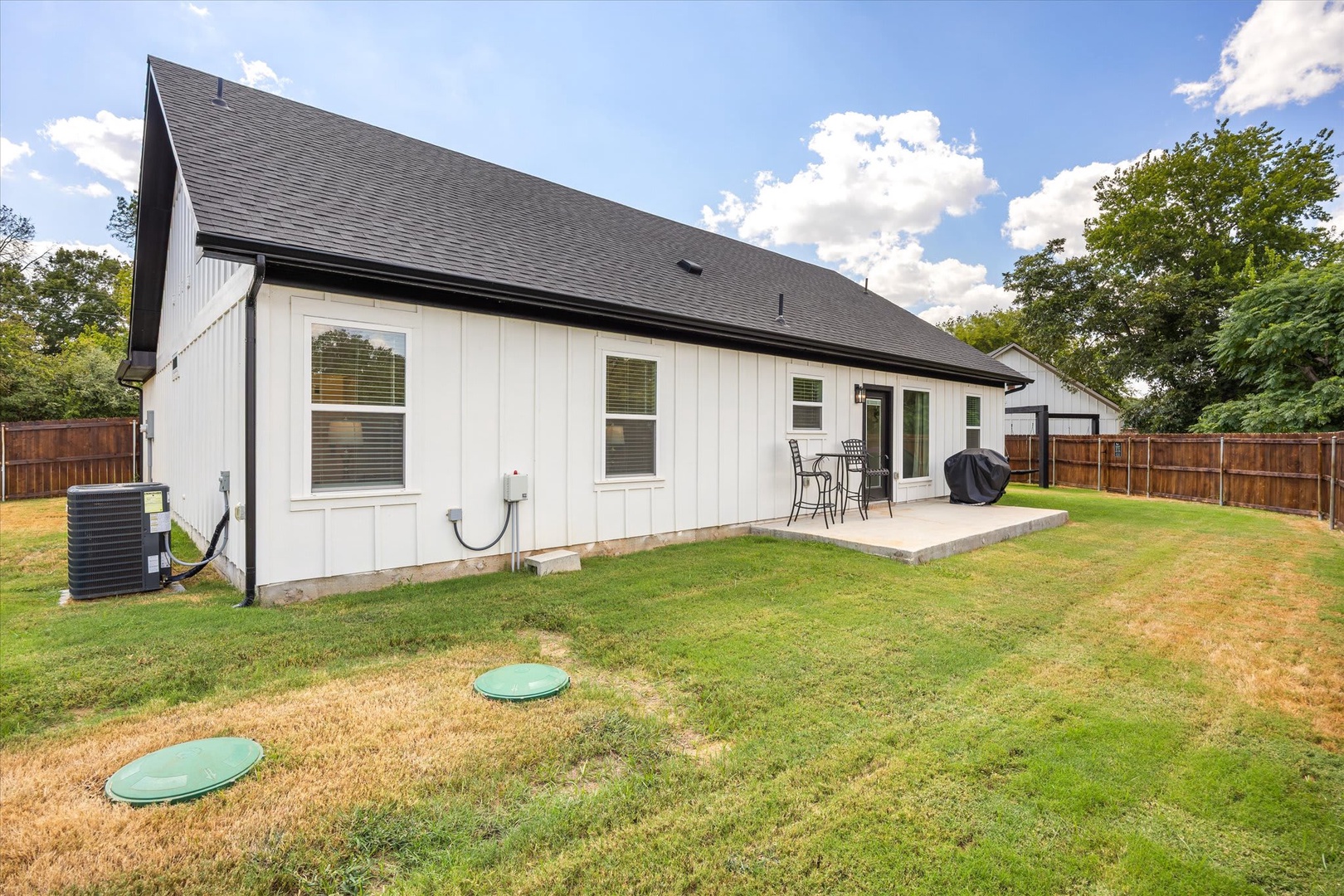 Modern farmhouse-style retreat set on a private lot with a spacious backyard and covered patio for outdoor gatherings.