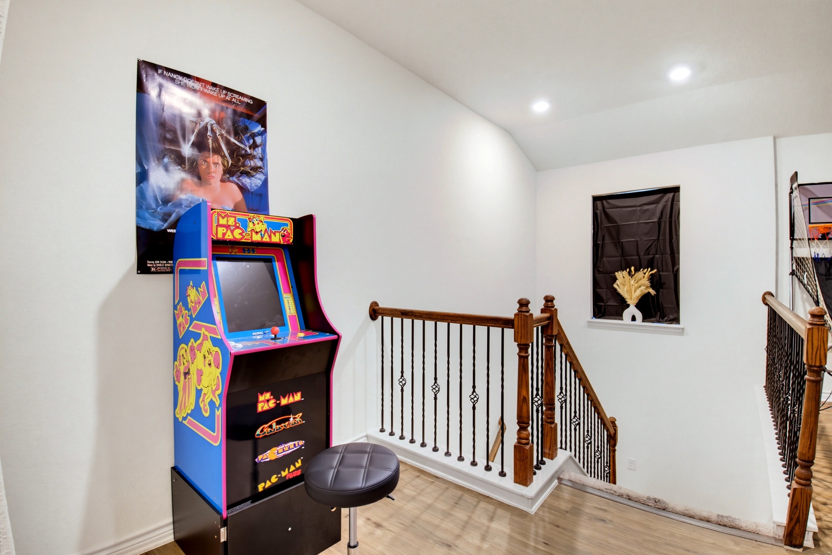 A classic arcade game awaits your high score in this bright upstairs landing, adding a playful touch to the home's nostalgic charm.